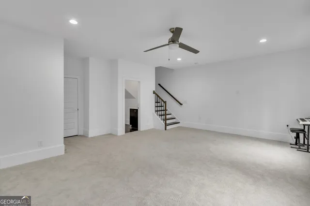 an empty room with staircase and white walls