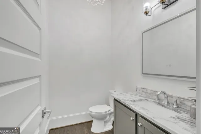a bathroom with a granite countertop toilet and a sink
