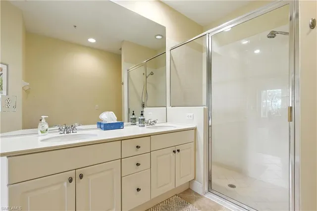 a bathroom with a double vanity sink mirror and shower
