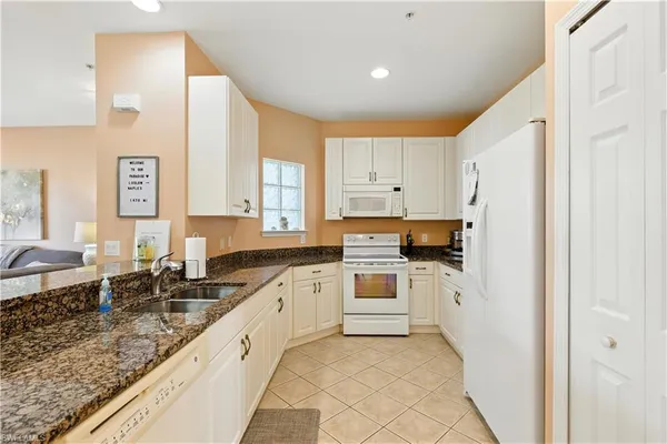 a kitchen with white cabinets and appliances