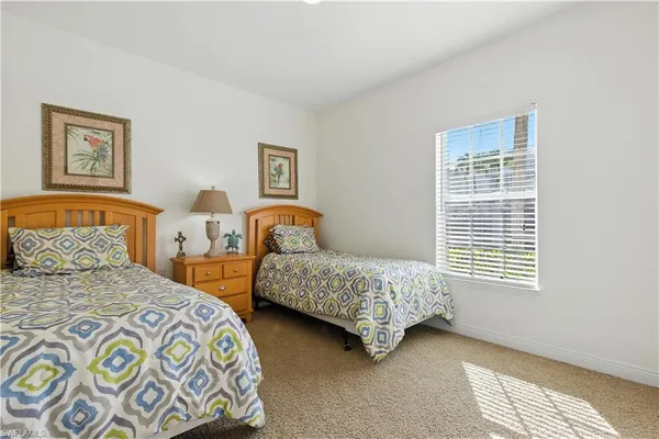 a bedroom with two beds and a window