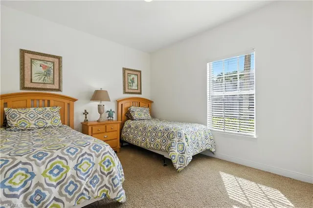 a bedroom with two beds and a window