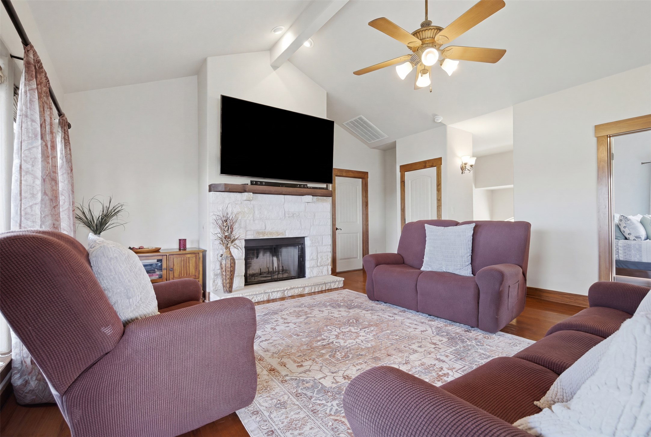 700 Augusta Circle Point Venture, TX 78645 - Photo 4 of 35 A comforting living space features a stone-clad fireplace and wood flooring.