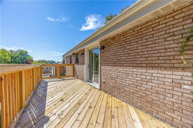 a view of a balcony with wooden floor and fence