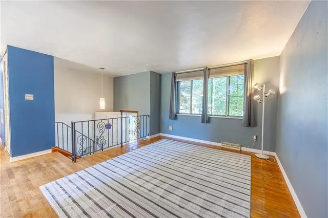 a view of a livingroom with wooden floor and furniture