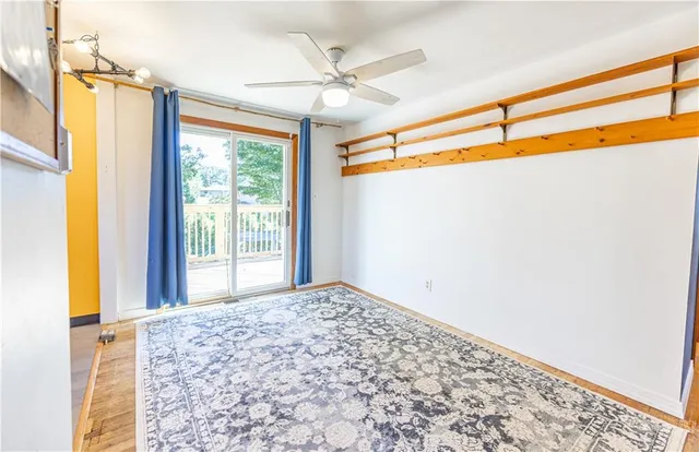 a view of a big room with a windows and ceiling fan
