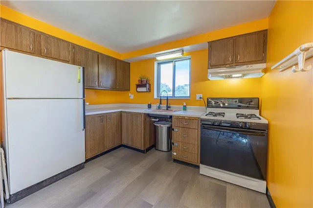 a kitchen with a stove a sink and a refrigerator