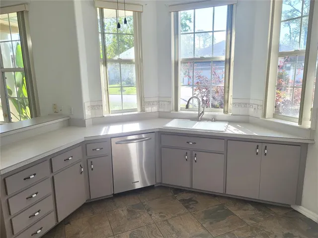 a white cabinets a sink and a window