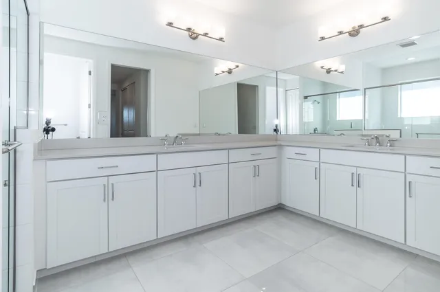 a bathroom with a double vanity sink and a mirror
