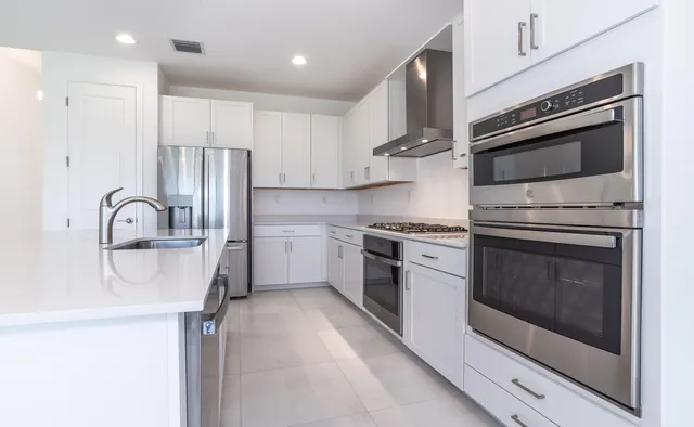a kitchen with a sink stainless steel appliances and cabinets