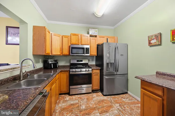 a kitchen with granite countertop a refrigerator and a sink