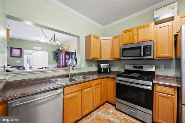 a kitchen with granite countertop a sink and stainless steel appliances