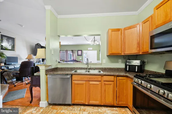 a kitchen with stainless steel appliances granite countertop a stove top oven a sink dishwasher and cabinets with wooden floor
