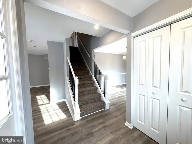a view of front door with wooden floor and stairs