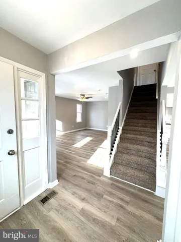 a view of entryway and hall with wooden floor