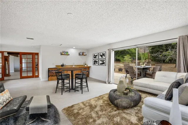 a living room with furniture a table and a large window