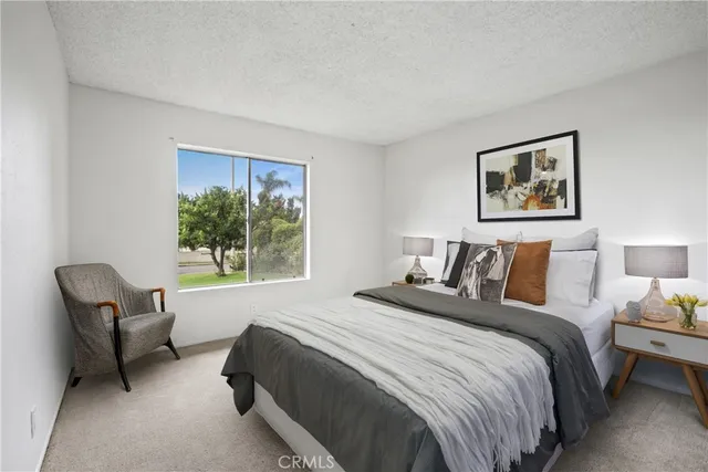 a bedroom with bed and a window with chair