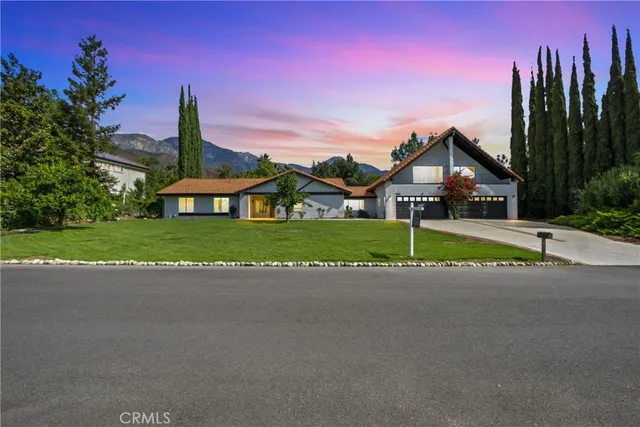 a view of a house with a yard and potted plants