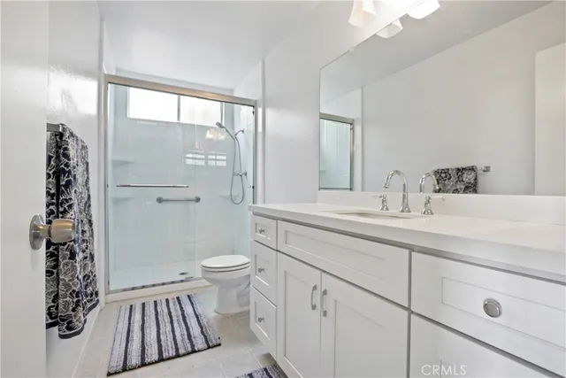 a bathroom with a sink a toilet a large mirror and shower