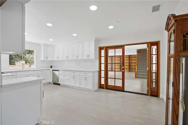 a large white kitchen with a large window