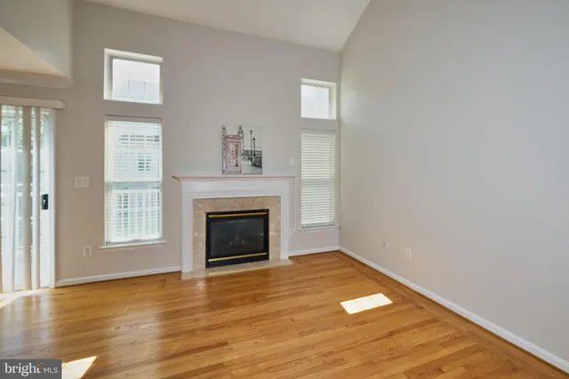 a view of empty room with wooden floor and fireplace