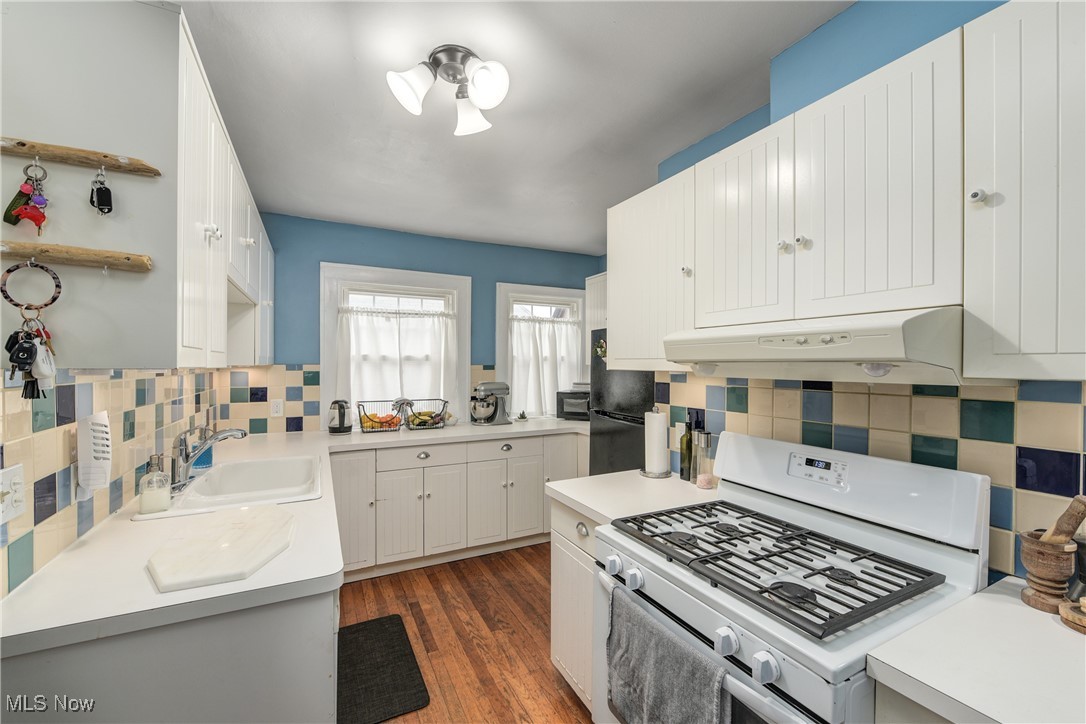 2852 Ludlow Road Cleveland, OH 44120 - Photo 19 of 50 Kitchen with white gas stove, sink, dark hardwood / wood-style flooring, white cabinetry, and tasteful backsplash