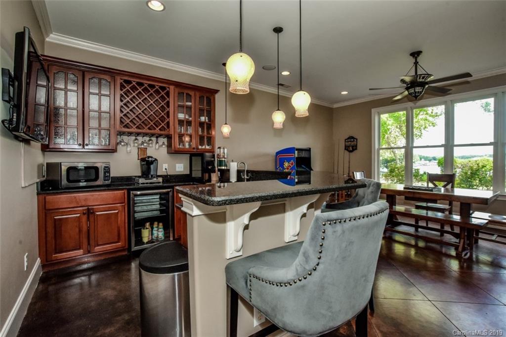 300 Ervin Road Mooresville, NC 28117 - Photo 28 of 32 a kitchen with granite countertop a stove a sink a dining table and chairs