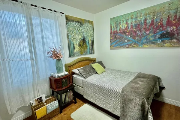 a bedroom with a bed and a painting on the wall