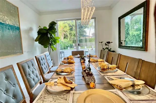 a view of a dining room with furniture a potted plant and wooden floor