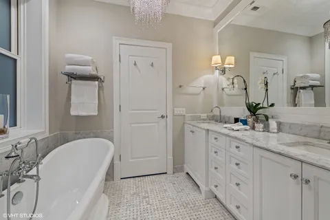 a bathroom with a granite countertop sink mirror and bathtub