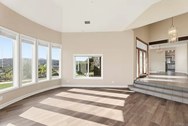 a view of a big room with chandelier and windows