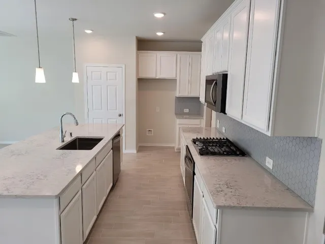 a kitchen with stainless steel appliances granite countertop a sink stove and refrigerator