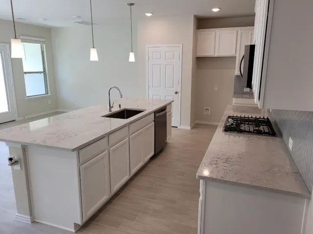 a kitchen with stainless steel appliances granite countertop a sink stove and refrigerator
