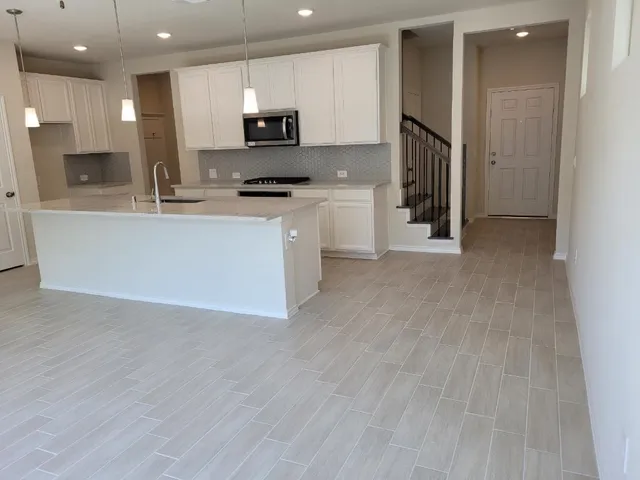 a kitchen with stainless steel appliances a refrigerator and a stove top oven