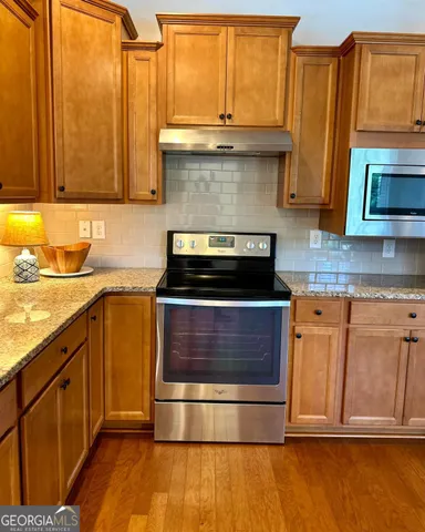 a kitchen with stainless steel appliances wooden cabinets and a stove top oven