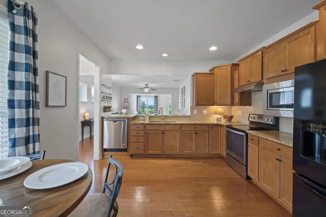 a kitchen with furniture a sink a counter space and stainless steel appliances
