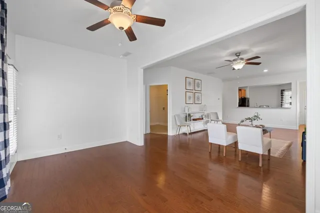 a view of a livingroom with furniture a ceiling fan and wooden floor