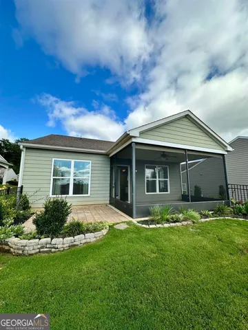 a view of a house with backyard sitting area and garden
