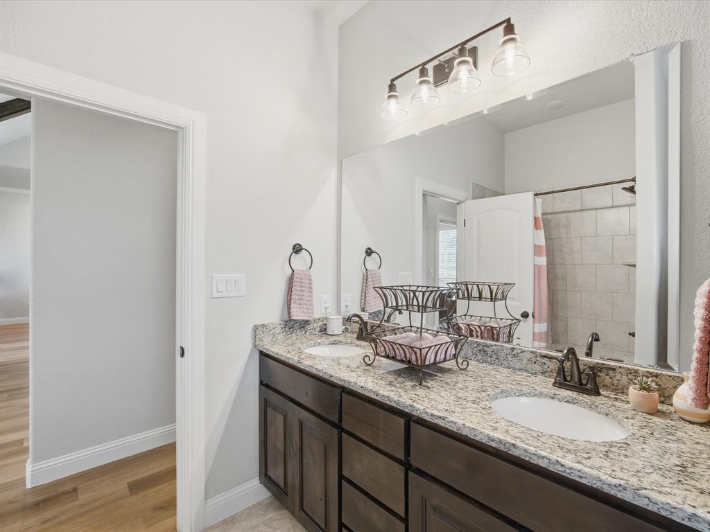 150 Quail Ridge Decatur, TX 76234 - Photo 29 of 32 a bathroom with a granite countertop sink and a mirror