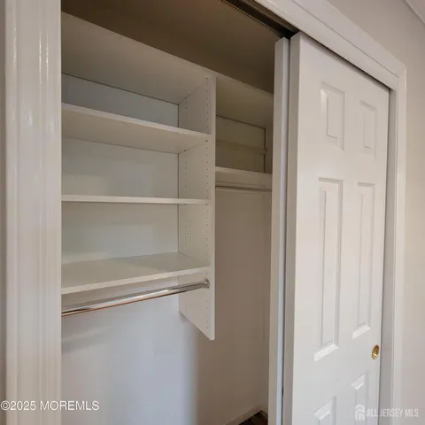a view of walk in closet with empty racks