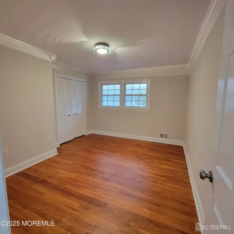an empty room with wooden floor and window