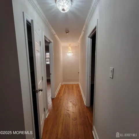 a view of a hallway with wooden floor and staircase