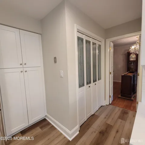 a view of a hallway with wooden floor and closet