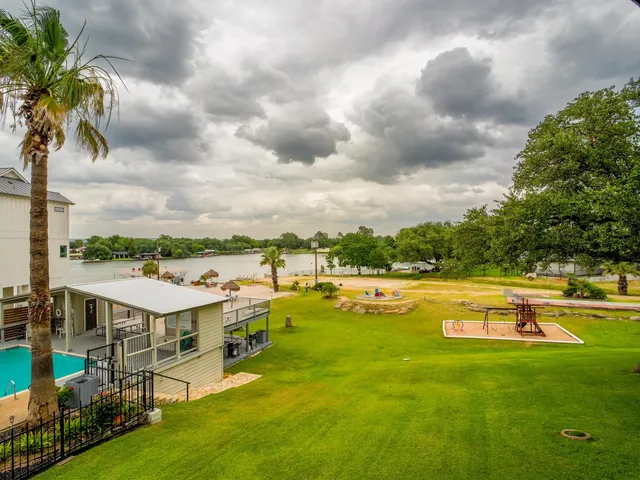 a view of a swimming pool with lawn chairs and a big yard