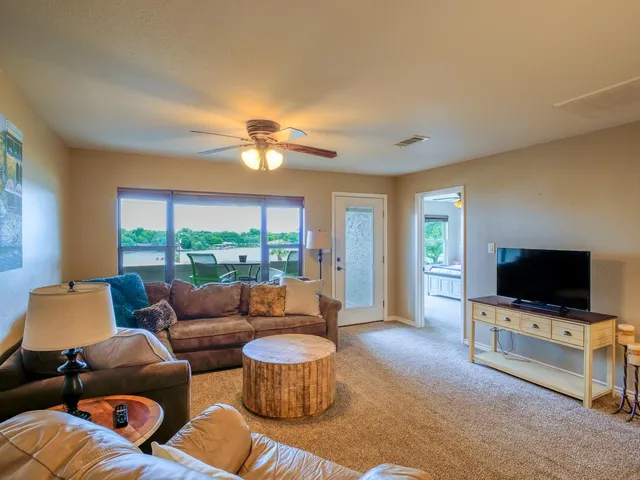 a living room with furniture a flat screen tv and a floor to ceiling window
