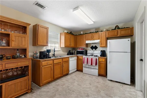 a kitchen with refrigerator a stove top oven and cabinets