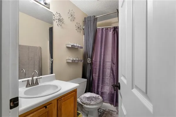 a bathroom with a granite countertop sink toilet mirror and shower
