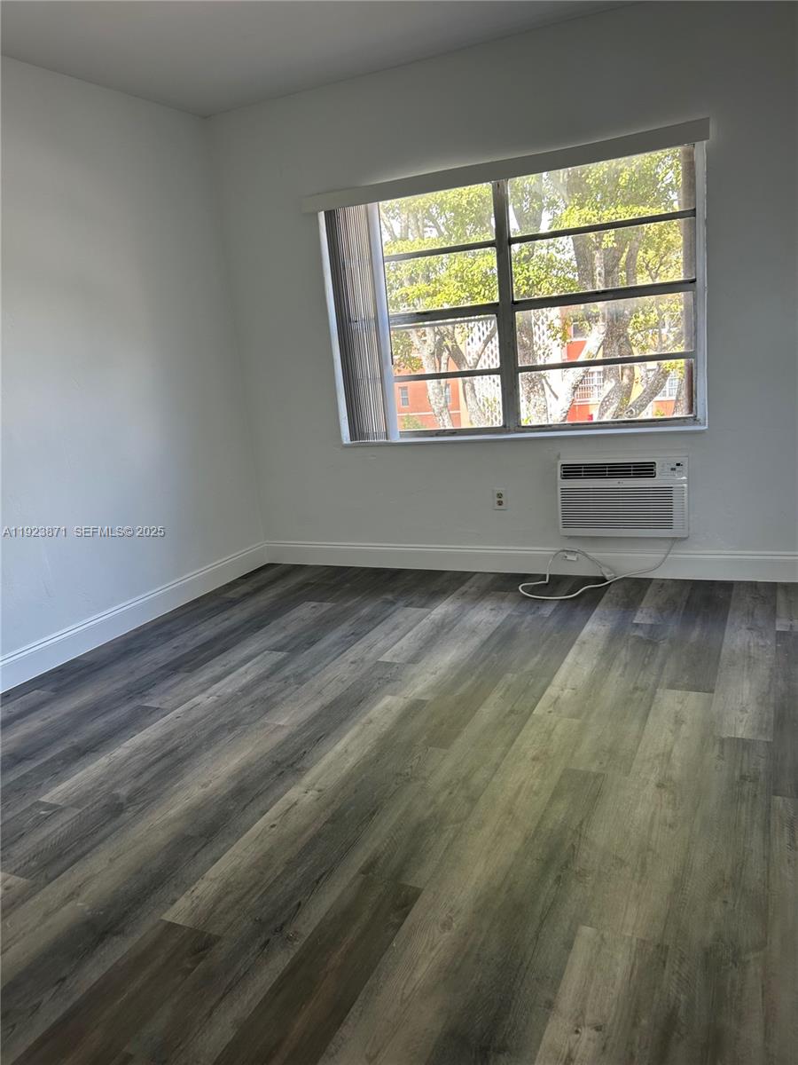 3400 Southwest 9th Terrace, Unit 2B Miami, FL 33135 - Photo 11 of 25 an empty room with wooden floor and windows