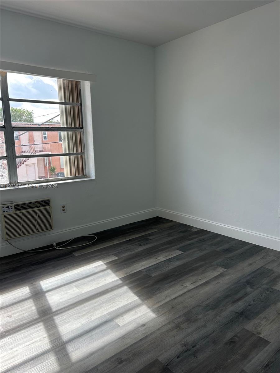3400 Southwest 9th Terrace, Unit 2B Miami, FL 33135 - Photo 15 of 25 a view of an empty room with wooden floor and a window