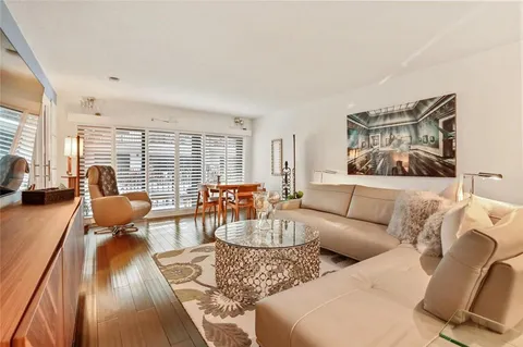 a dining room with wooden floor a chandelier a glass table and chairs